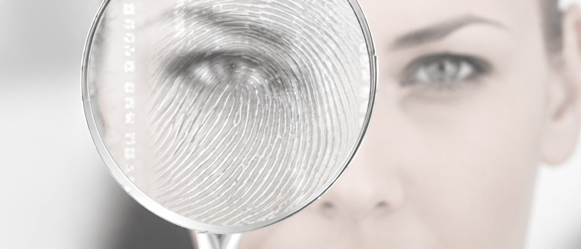 Woman examining a fingerprint through a magnifying glass, highlighting a focus on forensic investigation and detail-oriented analysis.